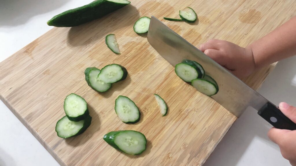 野菜を切る娘の手の写真